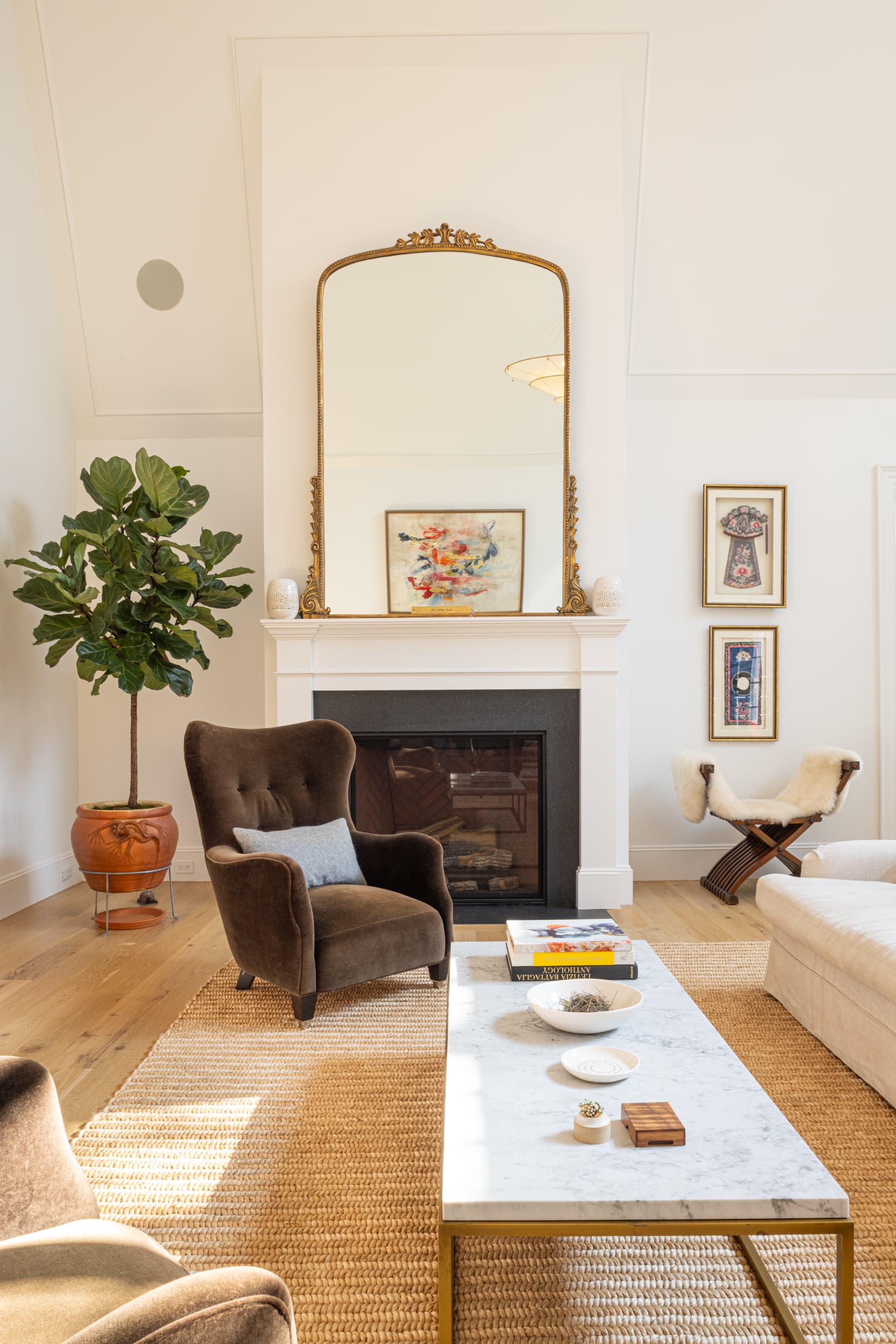 Living room with fireplace, couches, and large windows