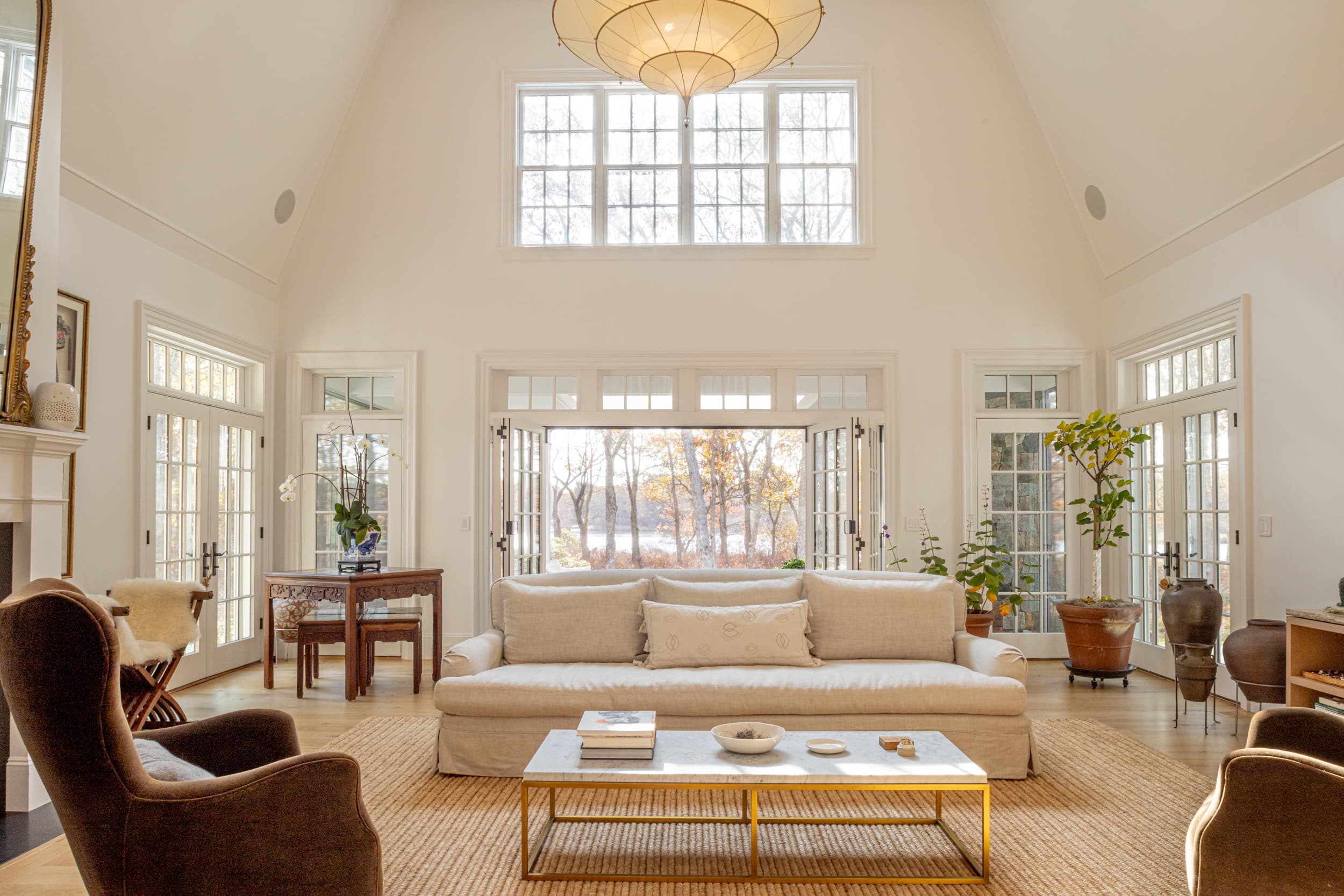 Living room with fireplace, couches, and large windows