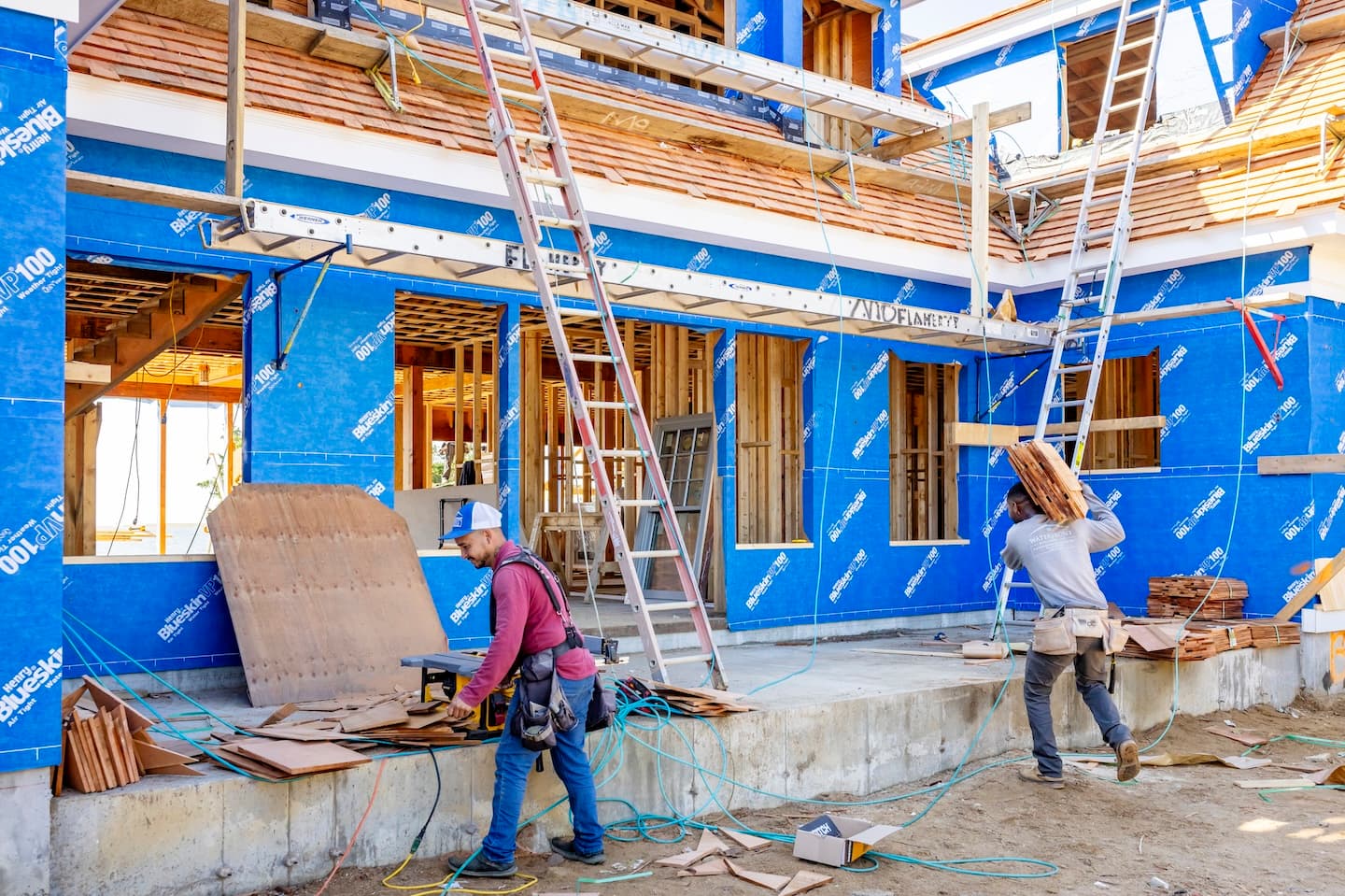 Waterfront Builders construction workers cutting and carrying shingles