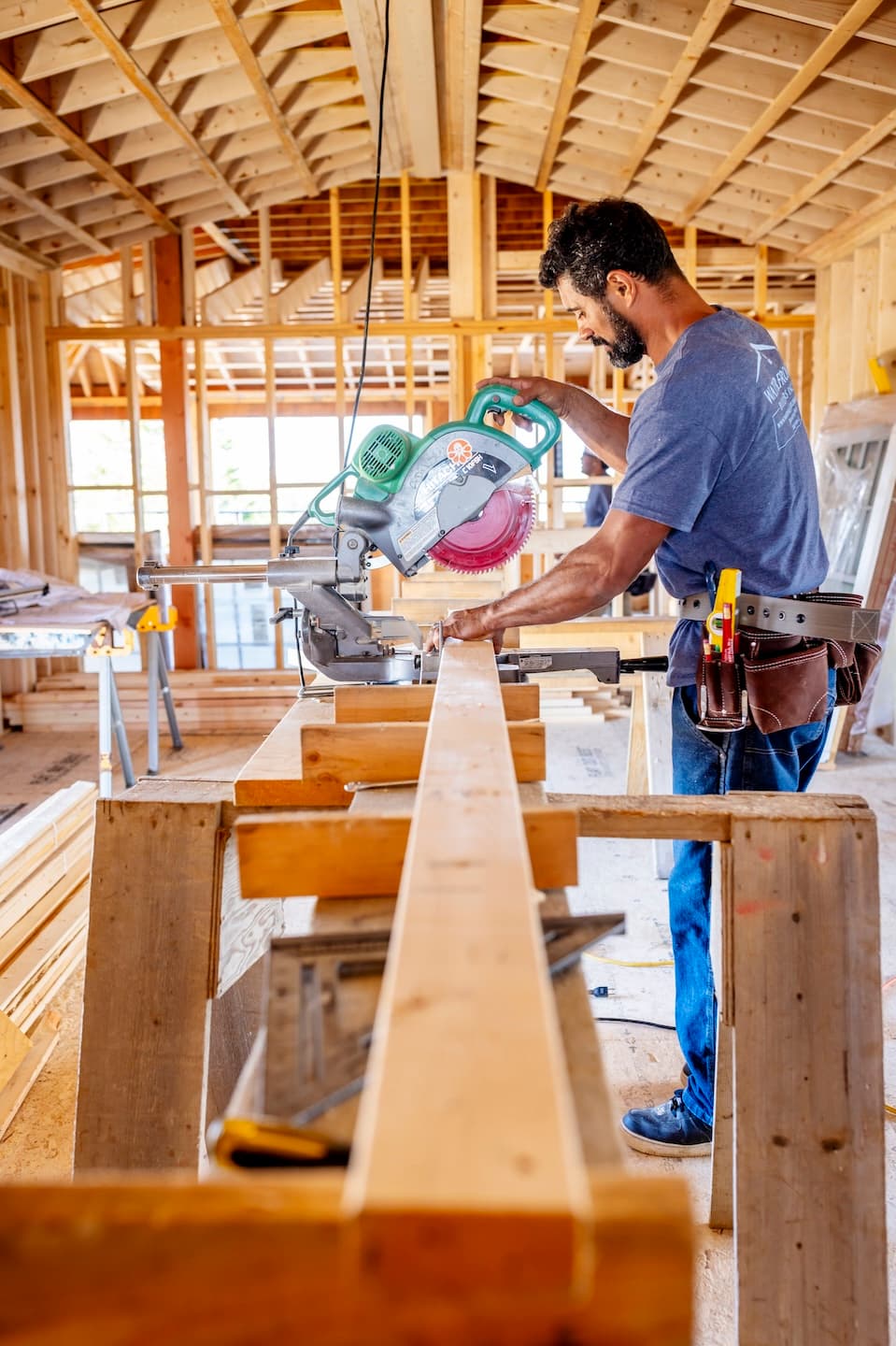 Waterfront Builders team member cutting a 2x4 with a chop saw