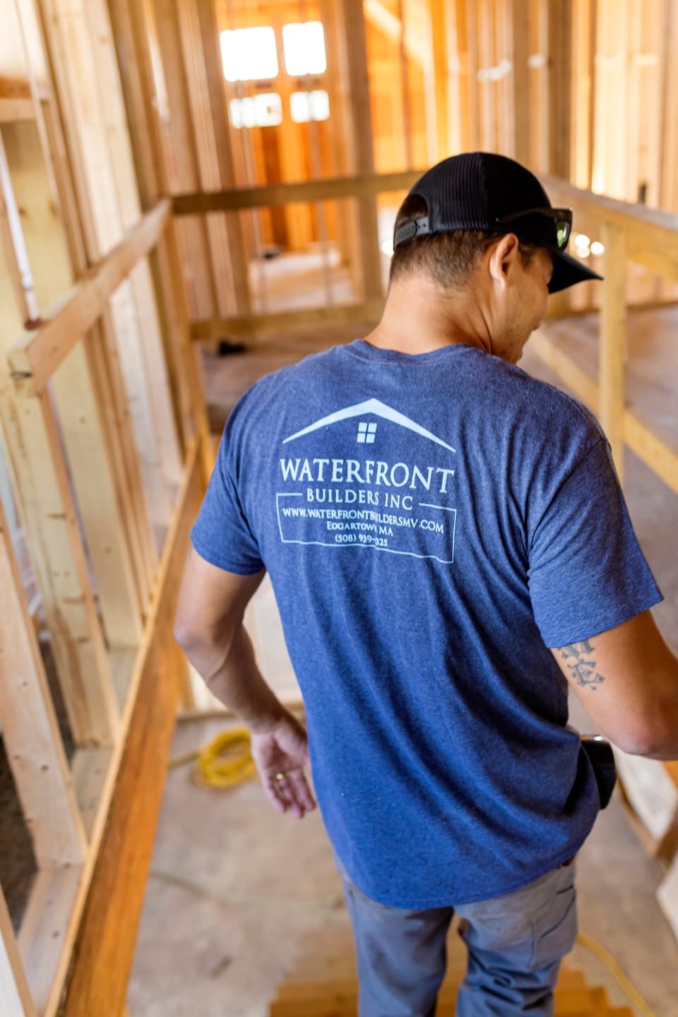 Waterfront Builders team member walking down the stairs inside a new home