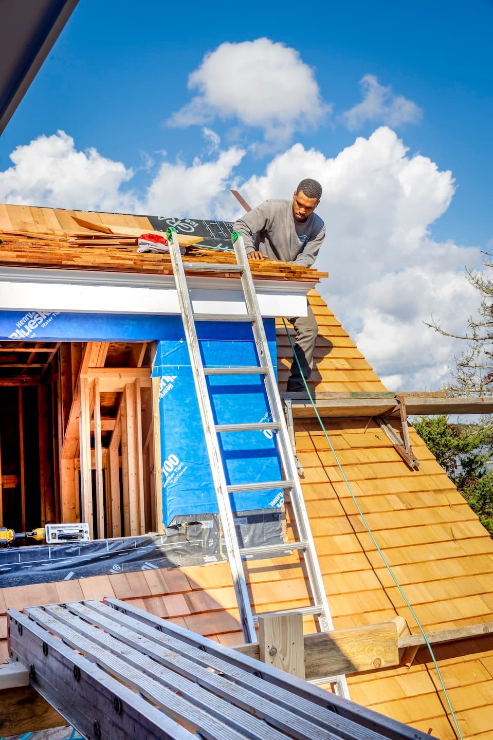 Waterfront Builders team member installing roof shingles on a new home